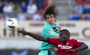 Michaël Pereira, joueur de Majorque, au duel avec le Barcelonais Carles Puyol, en mars 2012.