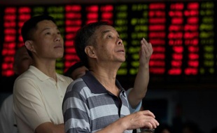 Des investisseurs surveillent les mouvements boursiers le 13 août 2015 chez un courtier de la Bourse de Shanghai