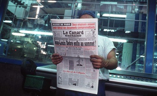 Dans une imprimerie, un ouvrier lit le journal satirique «Le Canard enchaîné».