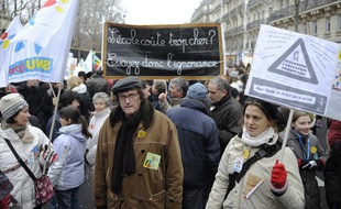 Des personnes tiennent des pancartes, le 22 janvier 2011 à Paris, lors d'une manifestation d'enseignants, de lycéens et d'étudiants pour dénoncer les 16.000 suppressions de postes dans l'Education nationale à la rentrée 2011.