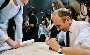Eric Zemmour fait une dédicace à un jeune.