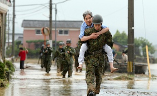 Les soldats japonais aident les résidents à évacuer les zones inondées de la ville d'Asakura, dans la préfecture de Fukuoka au Japon, le 6 juillet 2017.