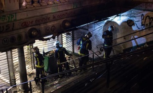 Des pompiers nettoient l'entrée de la station République saccagée pendant un rassemblement de Nuit Debout le 1er mai 2016