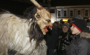 Un Krampus effraie un spectateur lors de la traditionnelle Krampuslauf, une parade où de jeunes hommes prennent l'apparence du démon le temps d'une soirée. A Hollabrunn en Autriche, le 30/11/2019