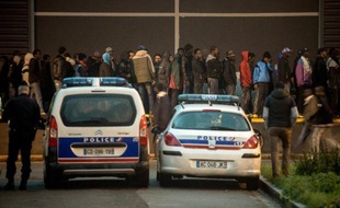 Des policiers surveillent une distribution de nourriture aux migrants sur le port de Calais le 29 octobre 2014