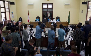 L'avocat d'un des deux Australiens condamné pour trafic de drogue (au milieu à gauche, face au juge) remet des documents à la cour lors de l'audience au tribunal à Jakarta, le 12 mars 2015