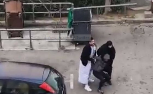 Deux policiers déguisés interpellent un homme.
