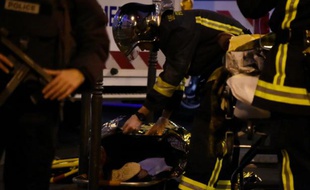 Un pompier vient en aide à une personne blessée le 14 novembre 2015 lors de la prise d'otages au Bataclan, à Paris