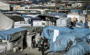 Des migrants discutent à l'extérieur de leurs tentes dans la Jungle de Calais, le 30 mars 2016