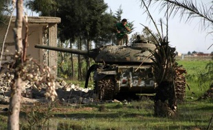 Un combattant rebelle sur le toit d'un char, le 28 mars 2014, près de la ville de Deir Ezzor, dans le nord-est de la Syrie