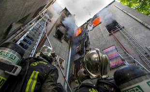 es pompiers luttent contre l'incendie d'un immeuble le 6 juin 2016 à Saint-Denis