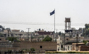 Un drapeau du groupe Etat islamique flotte au dessus de la ville de Tall Abyad, en Syrie, le 13 juin 2015