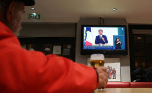 Illustration d'un homme regardant l'allocution d'Emmanuel Macron le 9 novembre 2021.