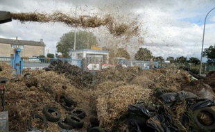 Des agriculteurs déversent de la paille devant un abattoir lors d'une manifestation contre la faiblesse des prix, à Villers-Bocage, le 19 juillet 2015
