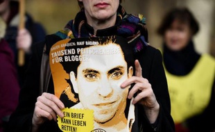 Un militant d'Amnesty Internation tient le 29 janvier 2015 un portrait du blogueur saoudien Raef Badaoui lors d'une manifestation devant l'amabassade d'Arabie saoudite à Berlin