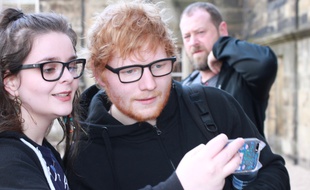 Le chanteur Ed Sheeran posant pour un selfie avec une fan à Glasgow (Ecosse)
