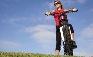 Une jeune femme se promène en vélo dans un parc