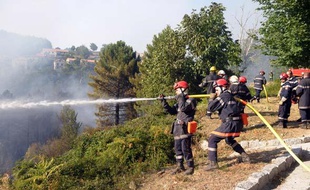 Les pompiers tentent d'éteindre le feu qui menace Aullène au sud de la Corse, le 25 juillet 2009.