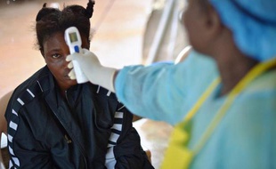 Une jeune fille suspectée d'avoir contracté le virus Ebola se fait prendre la température, le 16 août 2014 à Kenema, au Sierra Leone