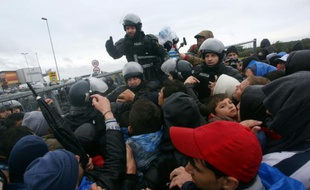Des policiers face aux migrants qui affluent le 19 octobre 2015 à Trnovec à la frontière de la Slovénie et de la Croatie