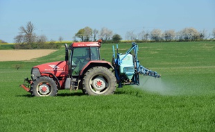 Illustration d'un agriculteur pulvérisant du désherbant dans son champ.
