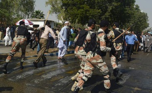 Des paramilitaires pakistanais chargent à coup de bâton des employés de PIA manifestant contre la privatisation de cette compagnie aérienne gouvernementale près de l'aéroport de Karachi, le 2 février 2016