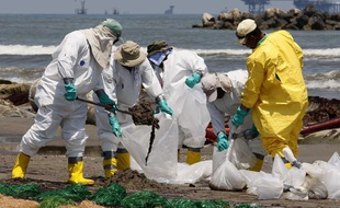 Des équipes de nettoyage s'affairent, le 24 mai 2010, pour effacer les traces de la marée noire sur la plage de Port Fourchon, en Louisiane.