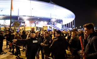 Football fans talk to a policeman securing an area outside the Stade de France stadium following the friendly football match between France and Germany in Saint-Denis, north of Paris, on November 13, 2015, after a series of gun attacks occurred across Paris as well as explosions outside the national stadium where France was hosting Germany. At least 18 people were killed, with at least 15 people killed at the Bataclan concert hall in central Paris, only around 200 metres from the former offices of Charlie Hebdo which were attacked by jihadists in January. AFP PHOTO / FRANCK FIFE