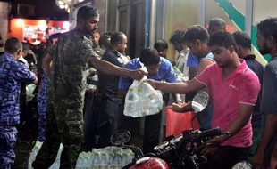 Distribution d'eau en bouteille, le 4 décembre 2014 à Malé, capitale des Maldives, privée d'eau potable après l'incendie d'une usine de désalinisation