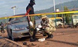 Des experts en déminage cherchent des indices sur les lieux d'une double exposition, le 3 octobre 2015 près d'Abuja, au Nigeria
