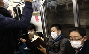 Des passagers équipés de masques à bord d'une rame de métro, à Tokyo le 28 janvier 2020.