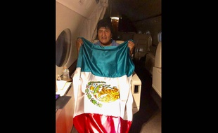Evo Morales pose avec le drapeau mexicain dans son vol vers Mexico lundi 11 novembre 2019.