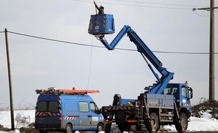 Des techniciens d'ERDF réparent une ligne électrique coupée par la neige à Ver-sur-Mer (Calvados), le 13 mars 2013.