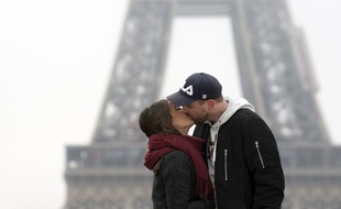 Un couple s'embrasse devant la tour Eiffel (image d'illustration).