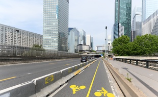 La piste cyclable provisoire Paris - La Défense avec un séparateur en béton.