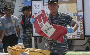 Un responsable indonésien montre le 5 janvier 2015 des débris de l'appareil d'AirAsia qui s'est abîmé en mer