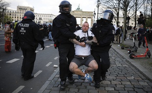 Des policiers allemands emmènent un manifestant qui participait à un rassemblement pour protester contre l'adoption par le gouvernement d'un durcissement de la loi anti-covid le 21 avril 2021.