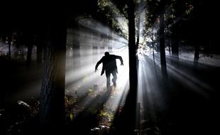 Illustration d'un homme courant dans les bois la nuit