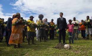 Emmanuel Macron plante un arbre.