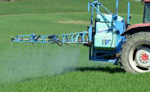 Illustration d'un tracteur pulvérisant un pesticide dans un champ.