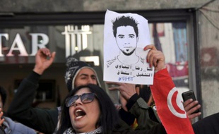 A Tunis, le 20 janvier 2016, une femme brandit le portrait de Ridha Yahyaoui, jeune chômeur de Kasserine décédé quelques jours plus tôt