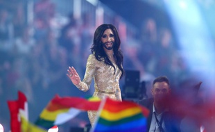 Conchita Wurst devant les drapeaux de la communauté LGBT