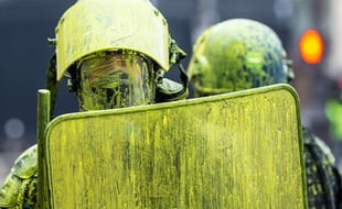 Des policiers sont recouverts de peinture jaune, samedi 1er décembre, à Paris.