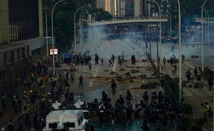 La police utilise du liquide de couleur bleue et des gaz lacrymogènes pour disperser les manifestants antigouvernementaux à Hong Kong, le 1er octobre.