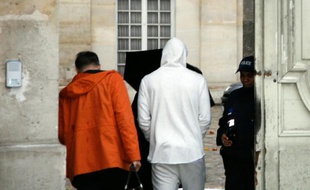 Le footballeur français Karim Benzema (c, en sweat-shirt blanc) arrive au commissariat de police de Versailles, le 4 novembre 2015