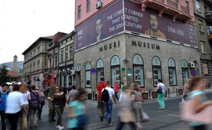 Des passants traversent la rue, où l'archiduc héritier d'Autriche François-Ferdinand et sa femme Sofia, ont été assassinés par Gavrilo Princip, à Sarajevo le 10 juin 2014