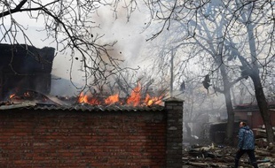Un pompier passe devant un bâtiment en feu suite à un bombardement ayant touché plusieurs maisons dans la ville ukrainienne de Donetsk, le 3 février 2015