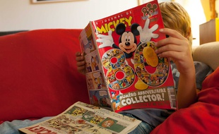 Un enfant lit le «Journal de Mickey» (illustration).