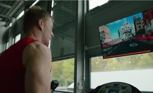 Capture d'écran d'une vidéo montrant l'astronaute britannique Tim Peake courir sur un tapis, virtuellement immergé dans le marathon de Londres grâce à un écran posé devant lui.