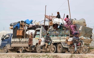 Des camions transportant meubles, matelas et couvertures près d'un camp de déplacés fuyant l'avancée des troupes syriennes dans les provinces d'Idleb et d'Alep, le 16 février 2020.